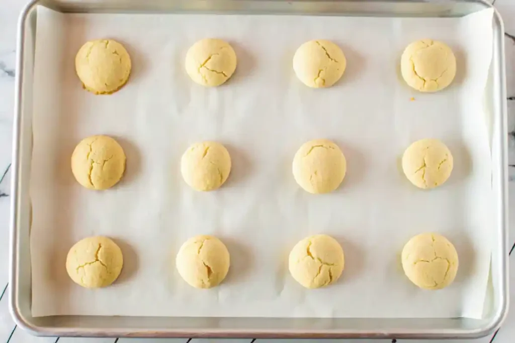 Freshly baked anise cookies arranged on a parchment-lined baking sheet.