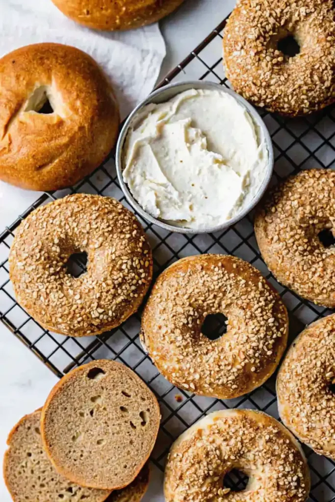 Gluten-free bagels and cream cheese on a cooling rack