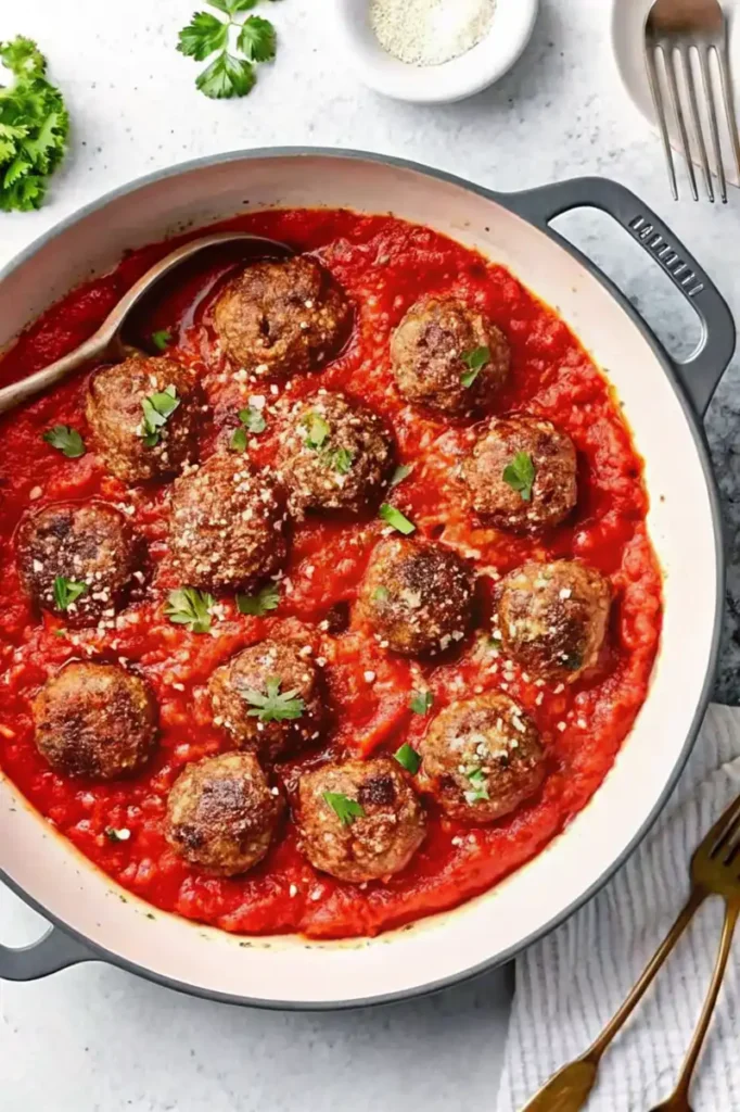 Gluten-free meatballs simmering in marinara sauce