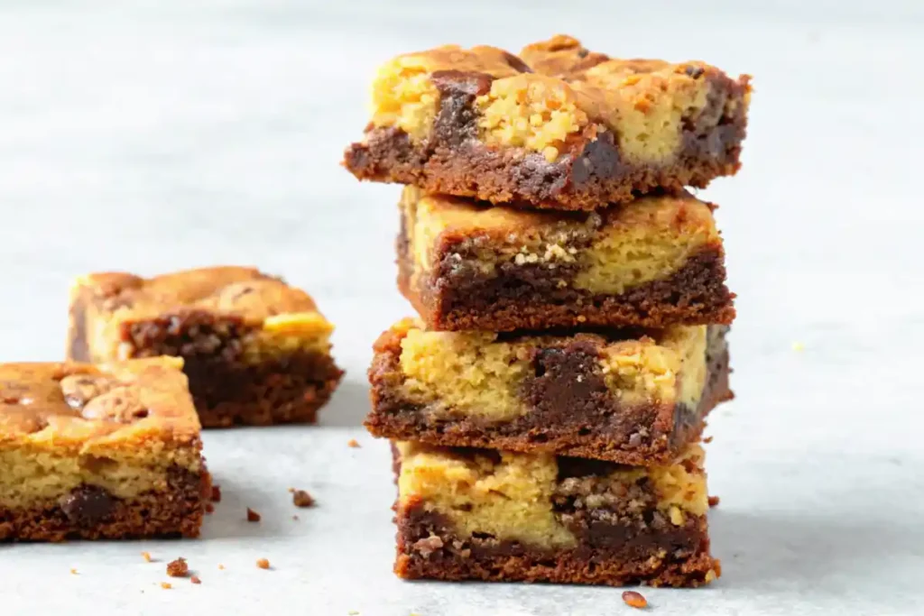 A stack of brookies showing rich chocolate brownie and golden cookie layers on a white background.