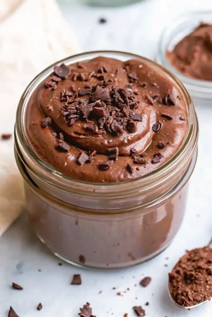 Rich and creamy chocolate protein pudding in a jar with chocolate shavings on top